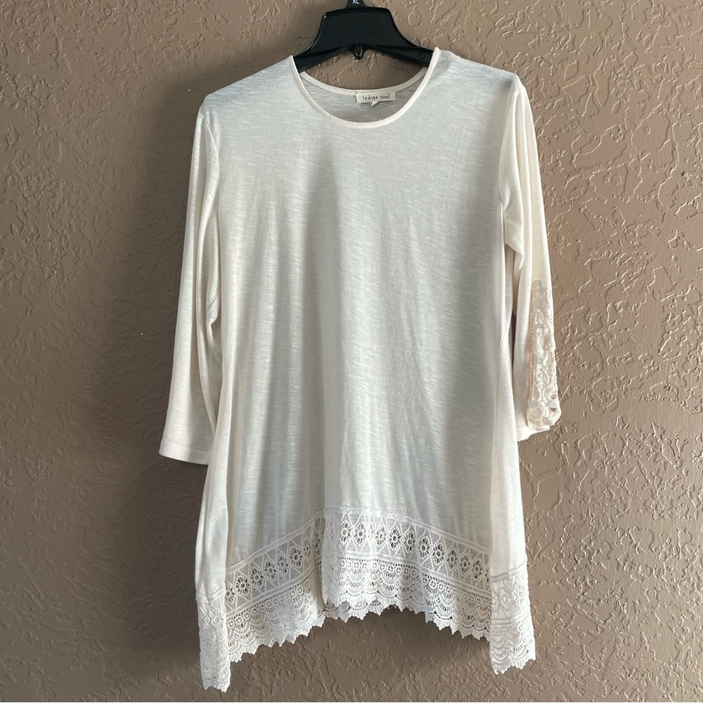 White tunic with lacy sleeves and hem.